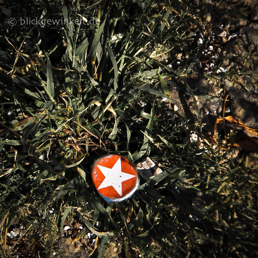 Kronkorken mit weißem Stern auf rotem Untergrund