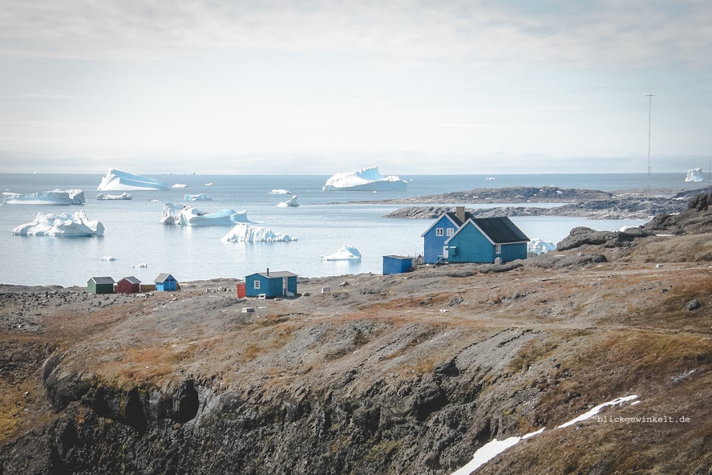 Grönland: wenig Einwohner, bunte Häuser, karges Land, Eis.