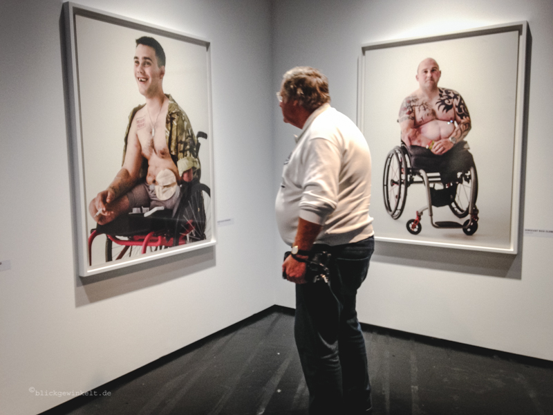 Ausstellung Photokina: Mann vor Bildern mit Kriegsversehrten