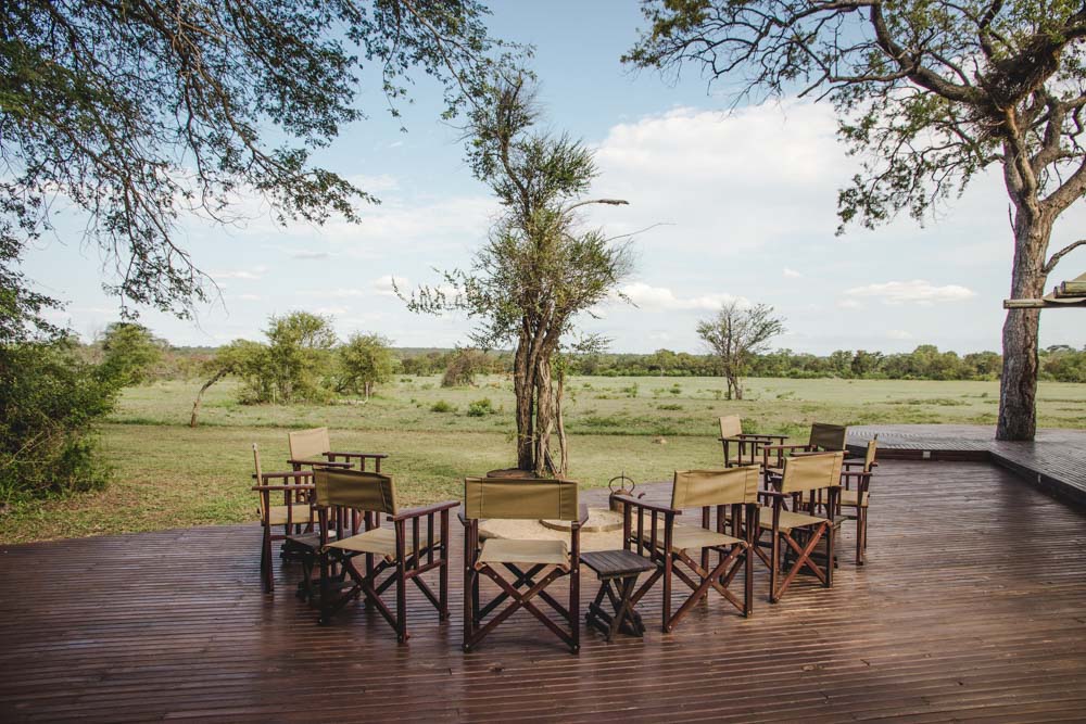 Feuerstelle mit Stühlen vor südafrikanischer Savanne bei den Rhino Walking Safaris