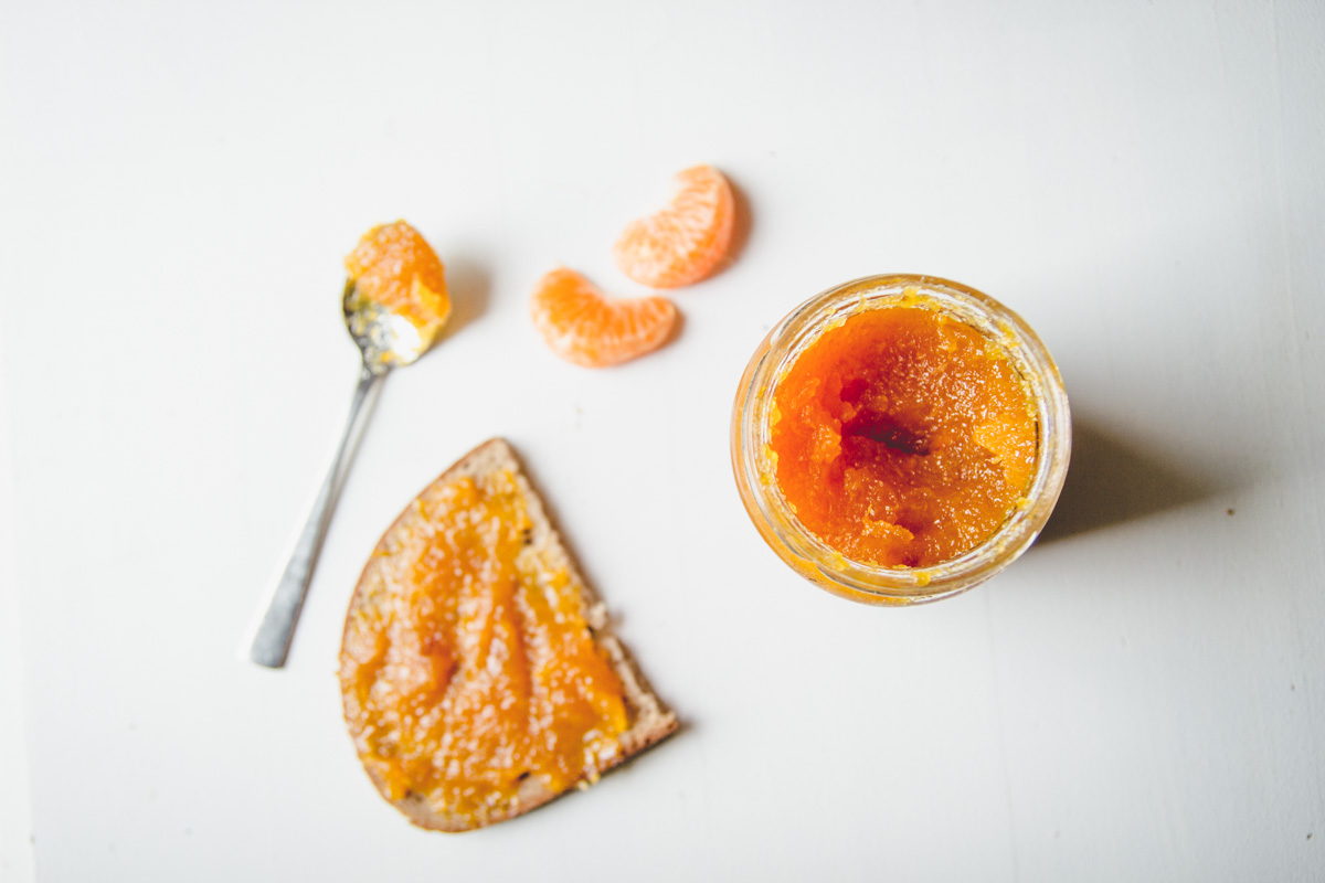 Selbstgemachte Mandarinenmarmelade auf Brot und im Glas
