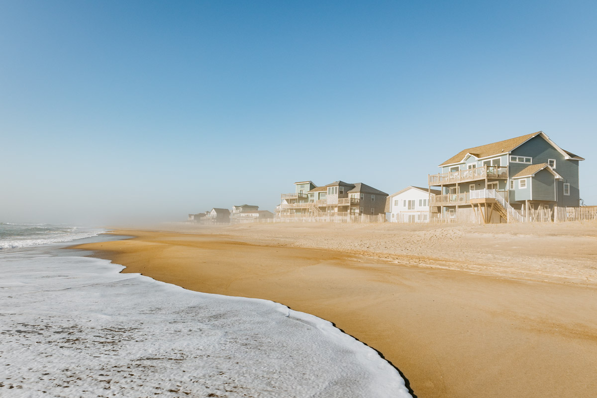 Strand mit Häusern im Nebel