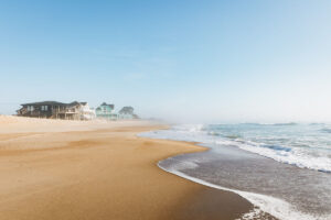 Strand mit Häusern im Nebel