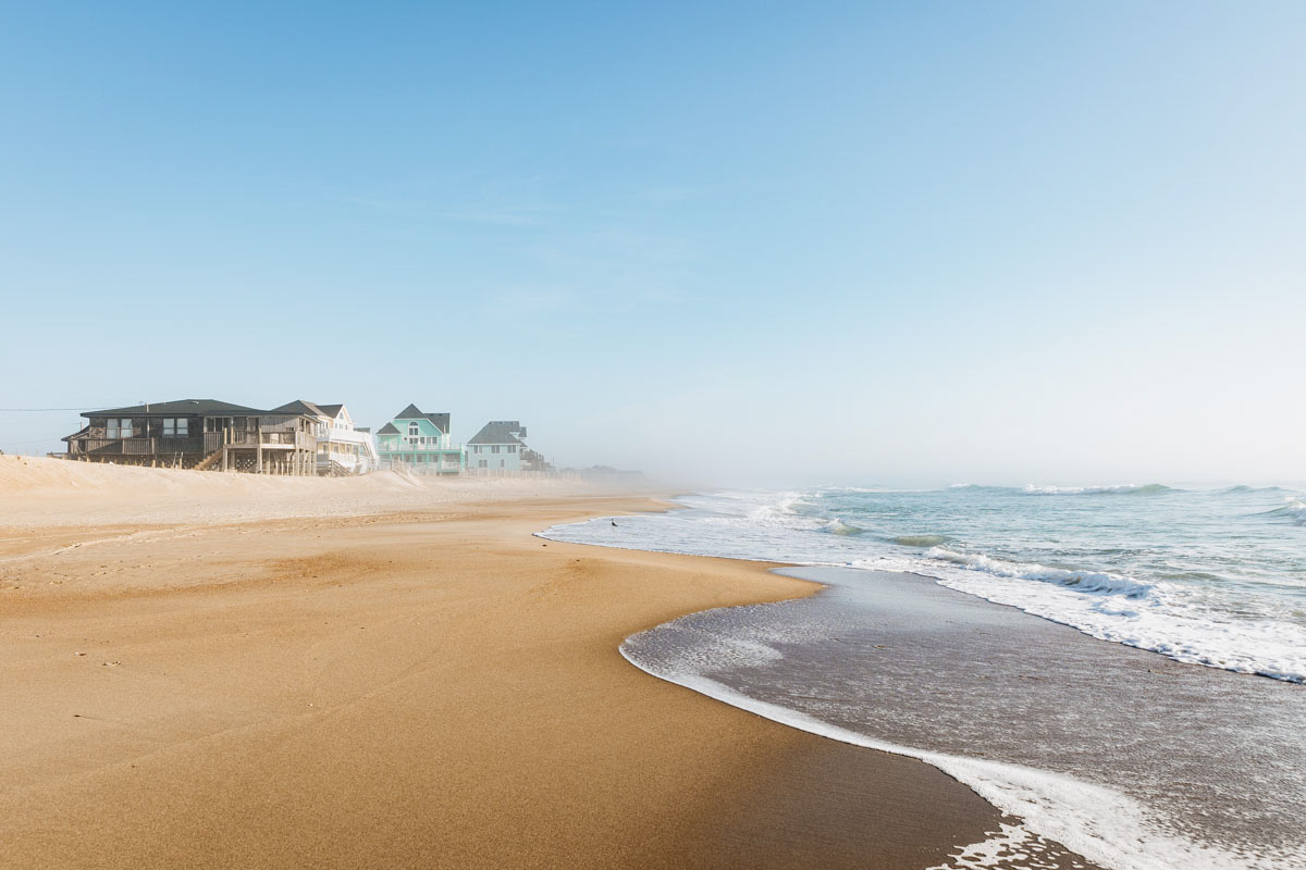 Strand mit Häusern im Nebel