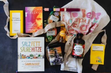 Bücher, Kerzen, Geschirrtuch, Aperitiv, Rohkakao auf Tisch dekoriert