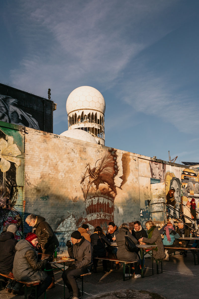 Radarstation, im Vordergrund Menschen an Tischen